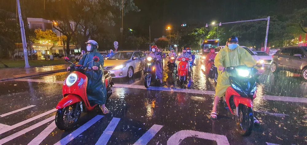 Người dân đội áo mưa đứng chờ đèn đỏ tại đường Trần Phú (quận Hải Châu). Ảnh: XUÂN QUỲNH Người dân đội áo mưa đứng chờ đèn đỏ tại đường Trần Phú (quận Hải Châu). Ảnh: XUÂN QUỲNH