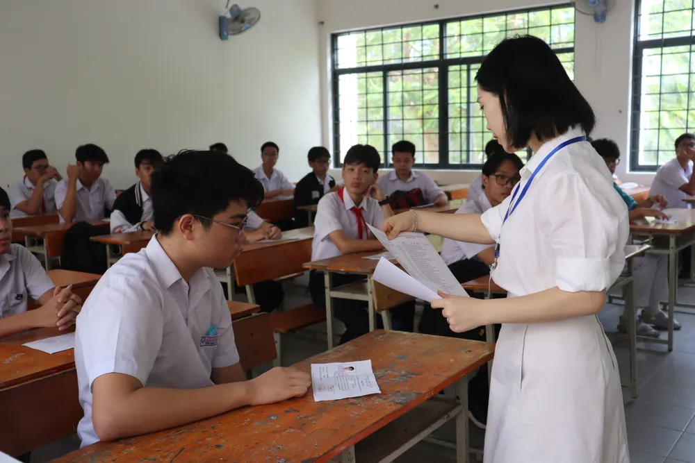 Cán bộ coi thi hướng dẫn thí sinh đối chiếu lại các thông tin trên giấy báo dự thi Cán bộ coi thi hướng dẫn thí sinh đối chiếu lại các thông tin trên giấy báo dự thi