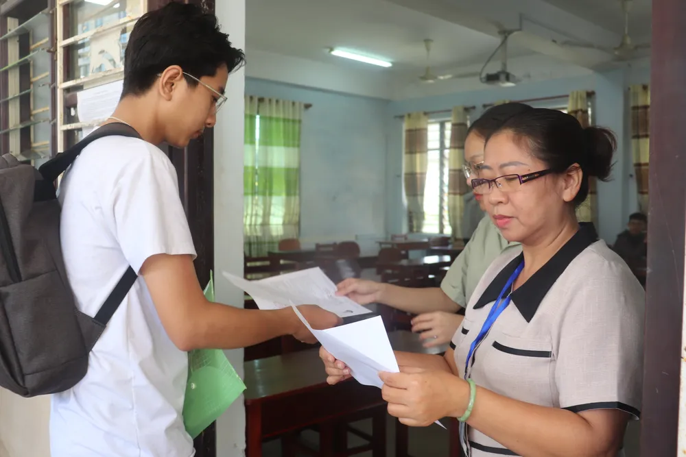 Giám thị đọc số báo danh tại điểm thi trường THPT Trần Phú. Ảnh: XUÂN QUỲNH