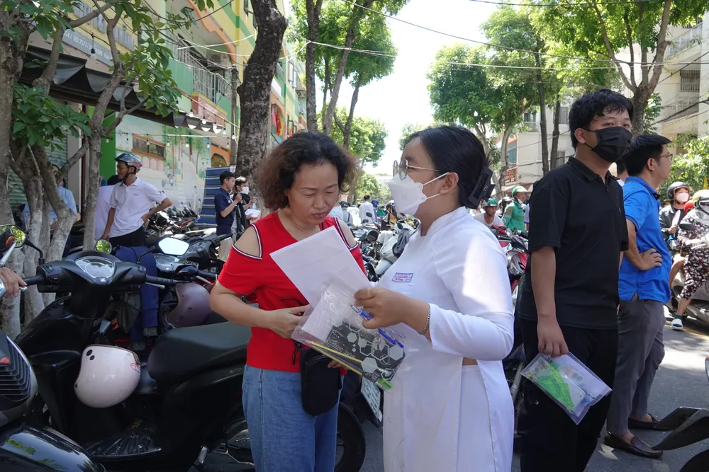 Một thí sinh vui vẻ đề cập đề thi năm nay với phụ huynh. Ảnh: XUÂN QUỲNH Một thí sinh vui vẻ đề cập đề thi năm nay với phụ huynh. Ảnh: XUÂN QUỲNH