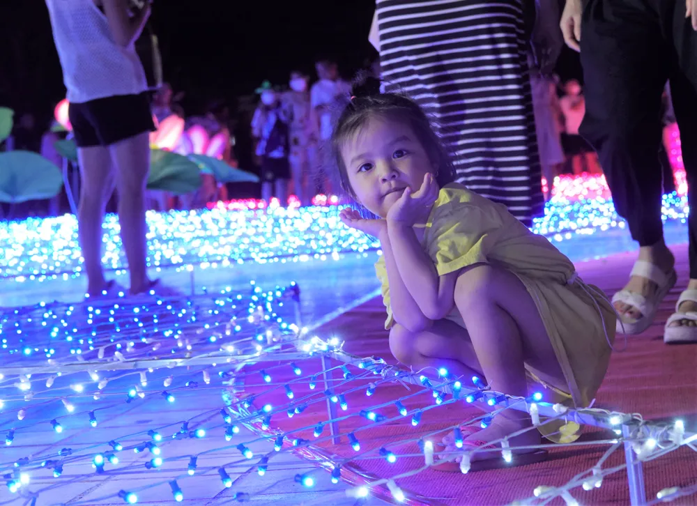 Một em bé đang tạo kiểu ngay cạnh không gian vườn hoa anh Đào. Ảnh: XUÂN QUỲNH Một em bé đang tạo kiểu ngay cạnh không gian vườn hoa anh Đào. Ảnh: XUÂN QUỲNH