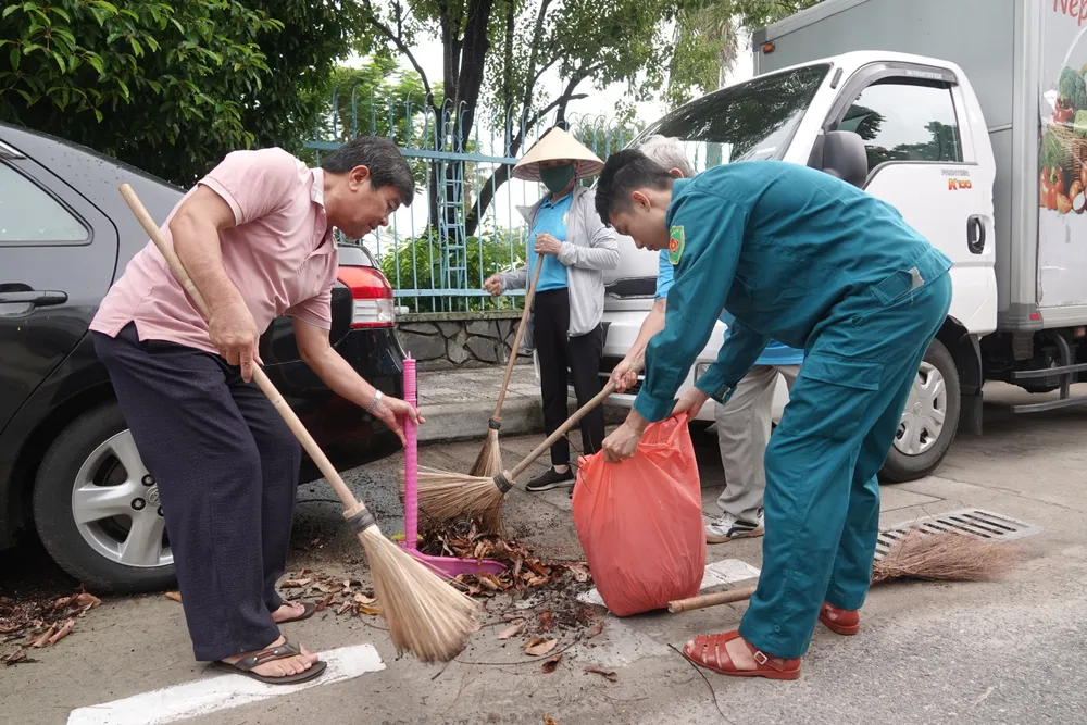 Một nhóm hội đoàn thể phường Thanh Bình dọn vệ sinh tại đường Cao Thắng. Ảnh: XUÂN QUỲNH