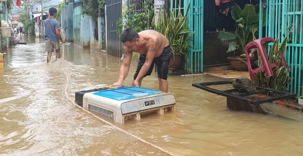 Máy quạt nước được người dân lấy nước lụt để rửa. Ảnh: XUÂN QUỲNH