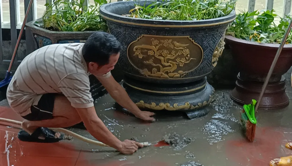 Ông Trần Viết Phúc khổ sở với việc dọn bùn mỗi khi mưa lớn. Ảnh: XUÂN QUỲNH Ông Trần Viết Phúc khổ sở với việc dọn bùn mỗi khi mưa lớn. Ảnh: XUÂN QUỲNH