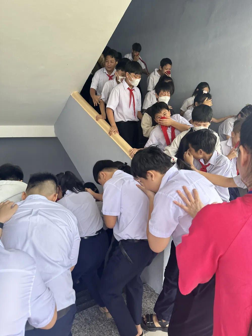 Các em được hướng dẫn cúi thấp và sử dụng khăn hoặc khẩu trang để di chuyển thoát khỏi khu vực có cháy Các em được hướng dẫn cúi thấp và sử dụng khăn hoặc khẩu trang để di chuyển thoát khỏi khu vực có cháy