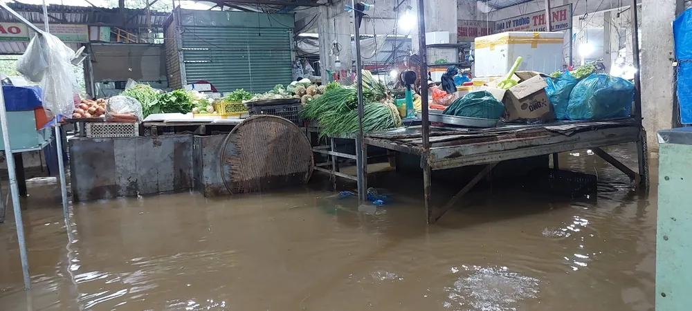 Bên trong chợ Thanh Vinh nước ngập sâu hơn 0,3m, tiểu thương phải di chuyển đồ đạc lên cao