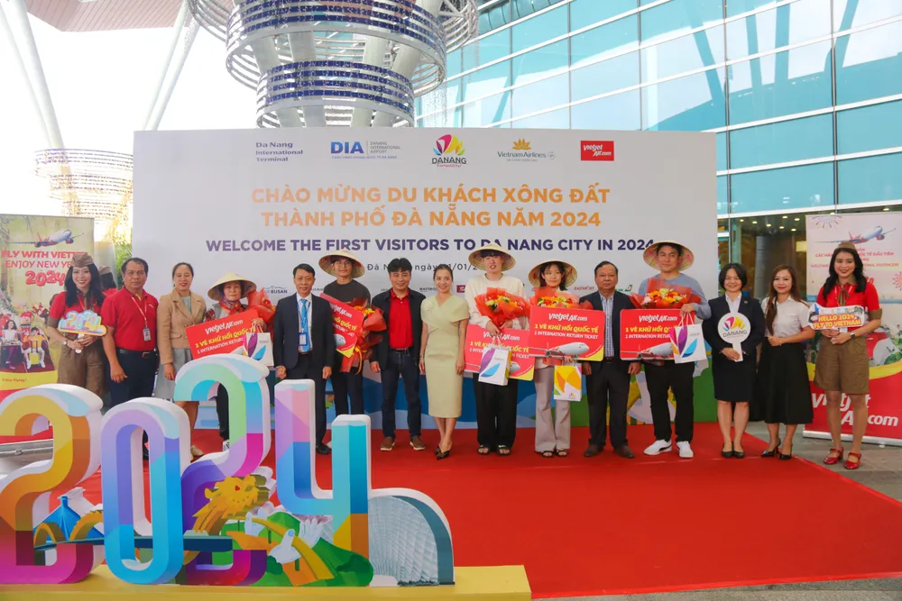 Những hành khách đầu tiên đến Đà Nẵng trên chuyến bay quốc tế được chào đón và tặng quà. Ảnh: XUÂN QUỲNH 20240101-img-0972-8118.jpg