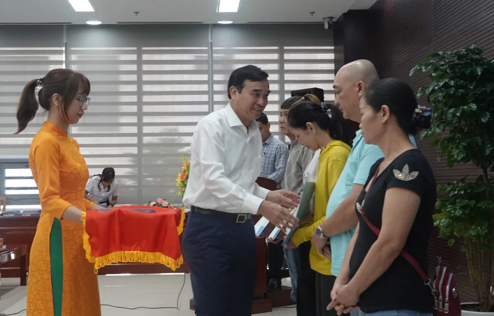 Ông Lê Trung Chinh, Chủ tịch UBND TP Đà Nẵng trao quyết định cho các hộ nghèo có hoàn cảnh đặc biệt khó khăn. Ảnh: XUÂN QUỲNH