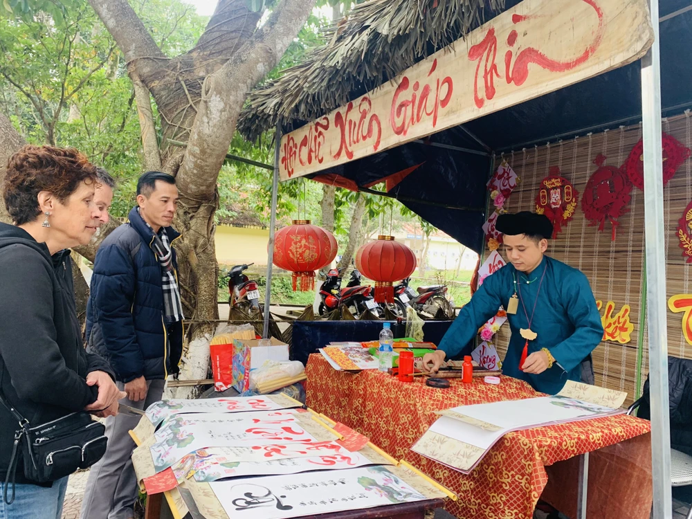 Du khách nước ngoài tham quan quầy viết chữ lưu niệm tại Khu di tích lịch sử Ngã ba Đồng Lộc. Ảnh: DƯƠNG QUANG du-khach-nuoc-ngoai-tham-quan-quay-viet-chu-luu-niem-tai-khu-di-tich-lich-su-nga-ba-dong-loc-huyen-can-loc-tinh-ha-tinh-dau-xuan-nam-moi-2024-8958.jpg