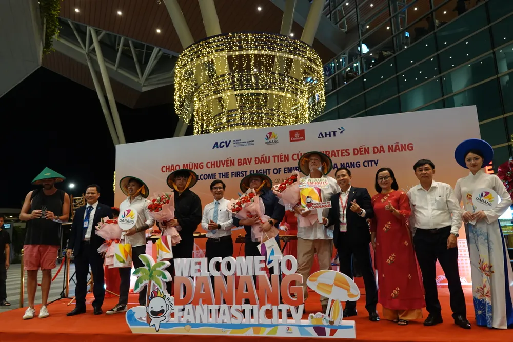 Các du khách đầu tiên được tặng hoa, quà lưu niệm. Ảnh: XUÂN QUỲNH 1000012259.jpg