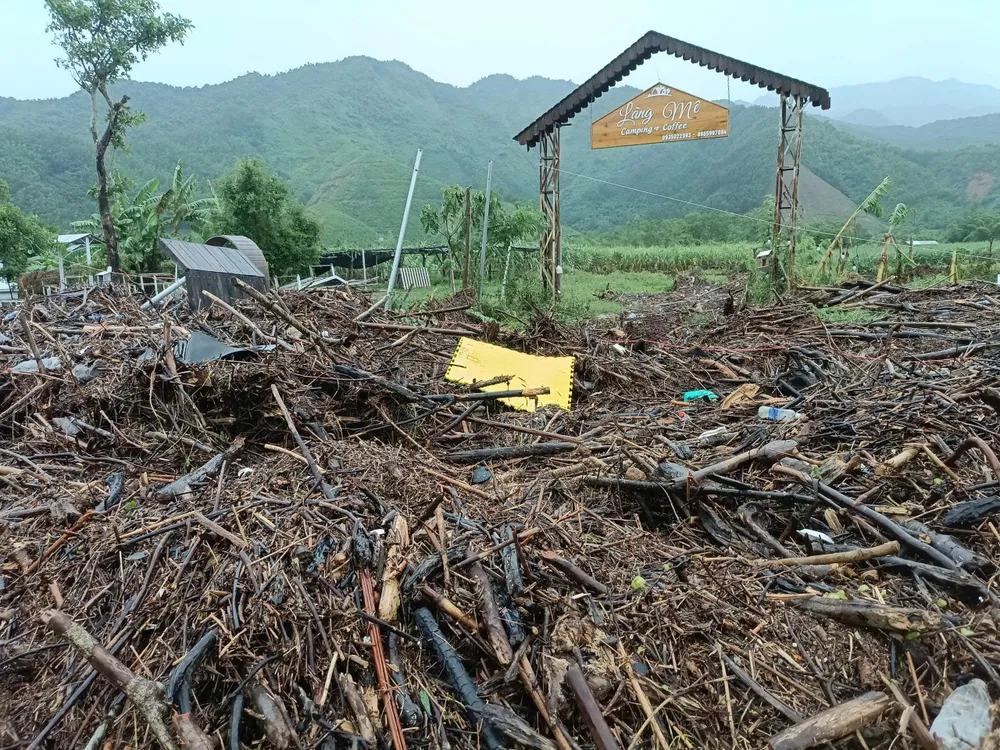 Trước cổng Làng Mê là đống củi được chất cao như núi sau trận mưa lớn. Ảnh: XUÂN QUỲNH 6.jpg