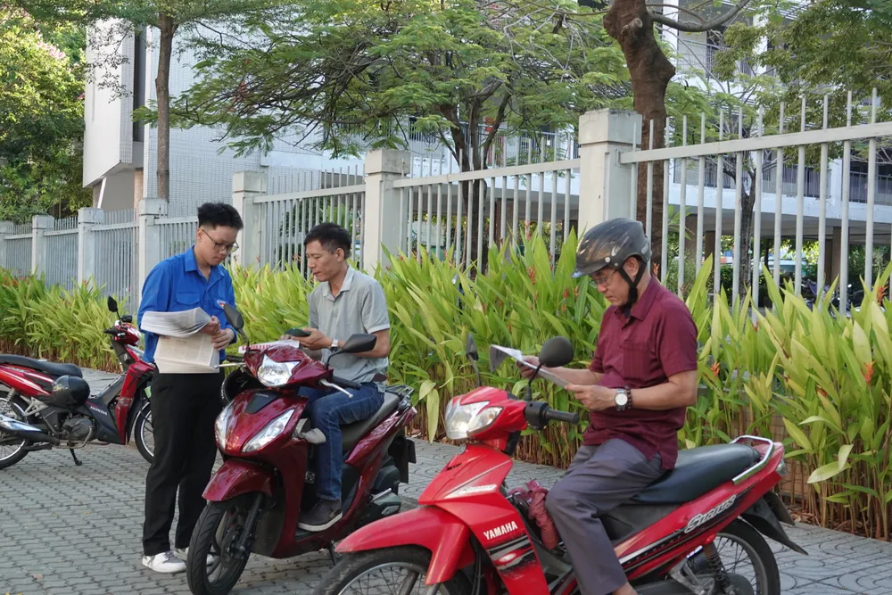 Lực lượng thanh niên phát báo in miễn phí cho phụ huynh. Ảnh: XUÂN QUỲNH DSC01279.JPG