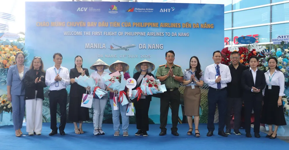 Tặng hoa và quà lưu niệm cho những du khách đầu tiên đặt chân đến TP Đà Nẵng. Ảnh: XUÂN QUỲNH z6760411144395_4c44e80e8100421dc4d90b59aa2c6a29.jpg