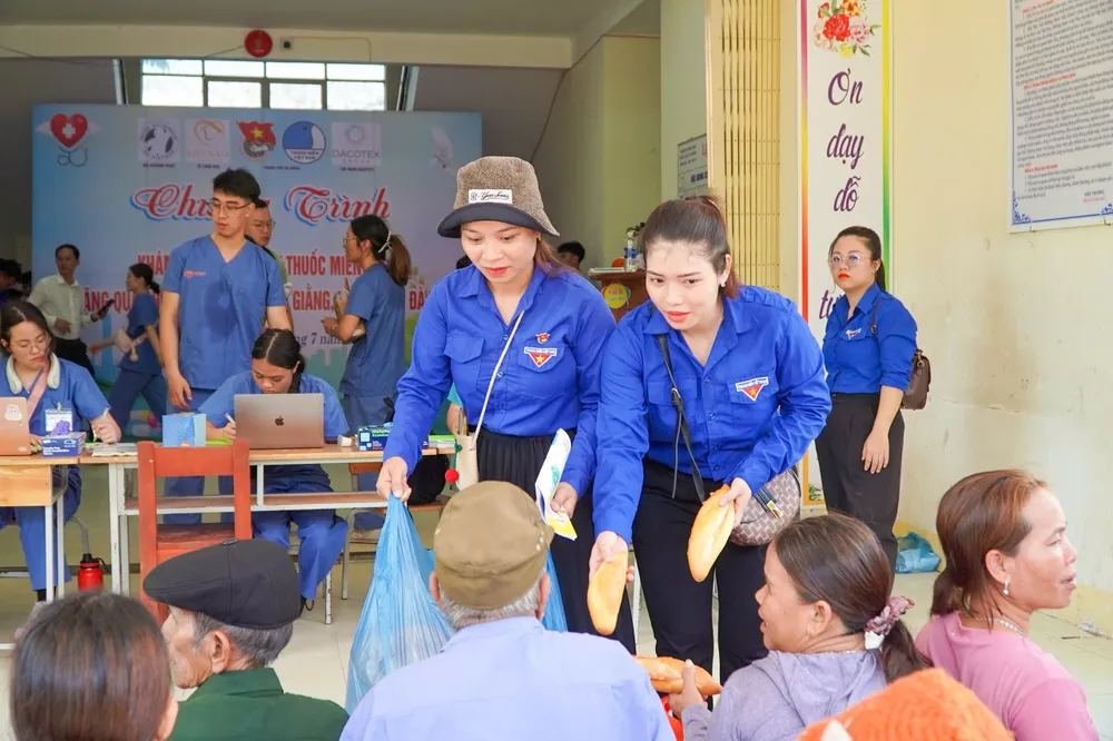 Đoàn viên, thanh niên phát bánh mì cho bà con trong lúc chờ khám z6802275995770_d54e936f803c303b3c9433463fbaee8c.jpg