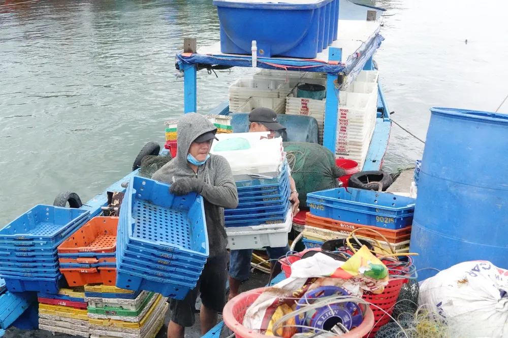 Ngư dân bốc vác đồ đạc lên bờ. Ảnh: XUÂN QUỲNH Ngư dân bốc vác đồ đạc lên bờ. Ảnh: XUÂN QUỲNH