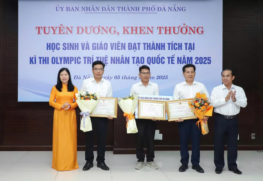 Ông Trần Anh Tuấn, Phó Chủ tịch UBND TP Đà Nẵng và bà Lê Thị Bích Thuận, giám đốc Sở GD-ĐT TP Đà Nẵng trao thưởng và chúc mừng thành tích các thầy cô z6980141766881_69cb555889c7d18e6580f040280c6e58.jpg