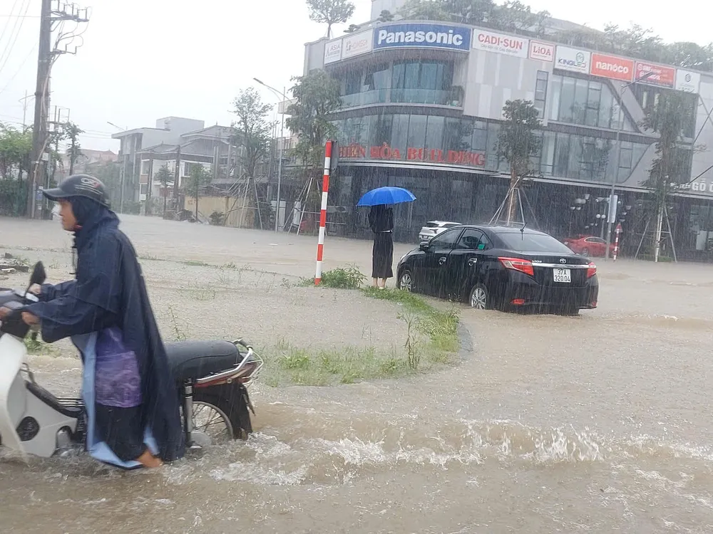 Ô tô, xe máy di chuyển khó khăn trong dòng nước ngập sâu. Ảnh: DUY CƯỜNG Ô tô, xe máy di chuyển khó khăn trong dòng nước ngập sâu. Ảnh: DUY CƯỜNG