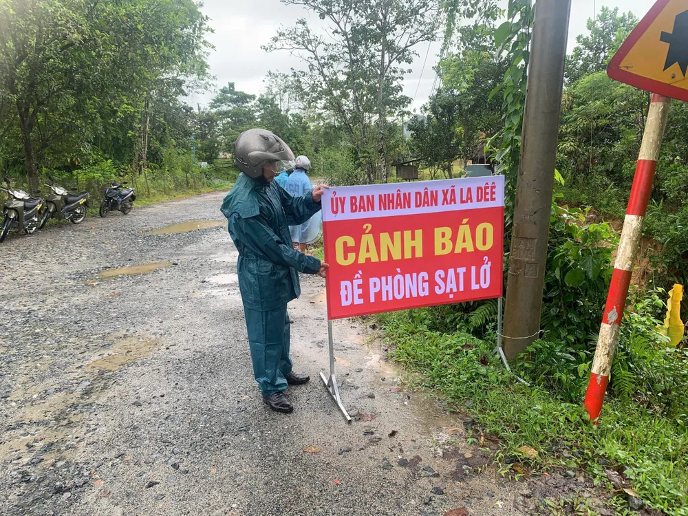 Lực lượng chức năng xã La Dêê cắm biển cảnh báo. Ảnh: BÙI THẾ ANH xa Tan Hiep (2).jpg