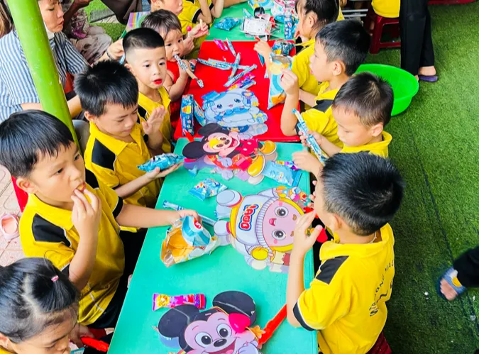 Các em nhỏ tại Trường Mẫu giáo Sơn Ca ăn bánh kẹo Trà Lieng (6).png