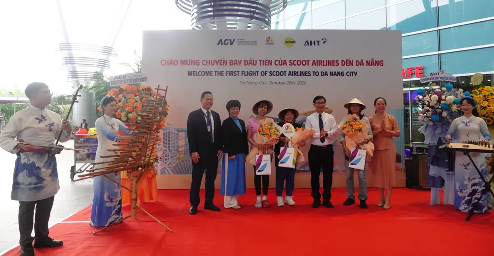 3 hành khách may mắn đầu tiên đáp sân bay Đà Nẵng đã được tặng hoa tươi, quà lưu niệm. Ảnh: XUÂN QUỲNH DSC06370.JPG