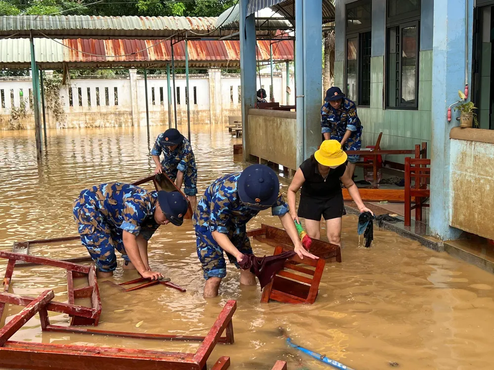 Cán bộ, chiến sĩ Trung đoàn 351 cùng cô giáo dọn dẹp bàn ghế dính bùn trung doan 351 (11).jpg