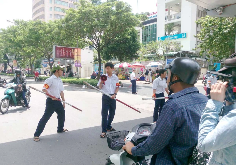 Đội trật tự học đường của Trường THPT chuyên Lê Hồng Phong (TPHCM) tham gia điều phối giao thông trước cổng trường giờ tan học. Ảnh: THU HƯỜNG