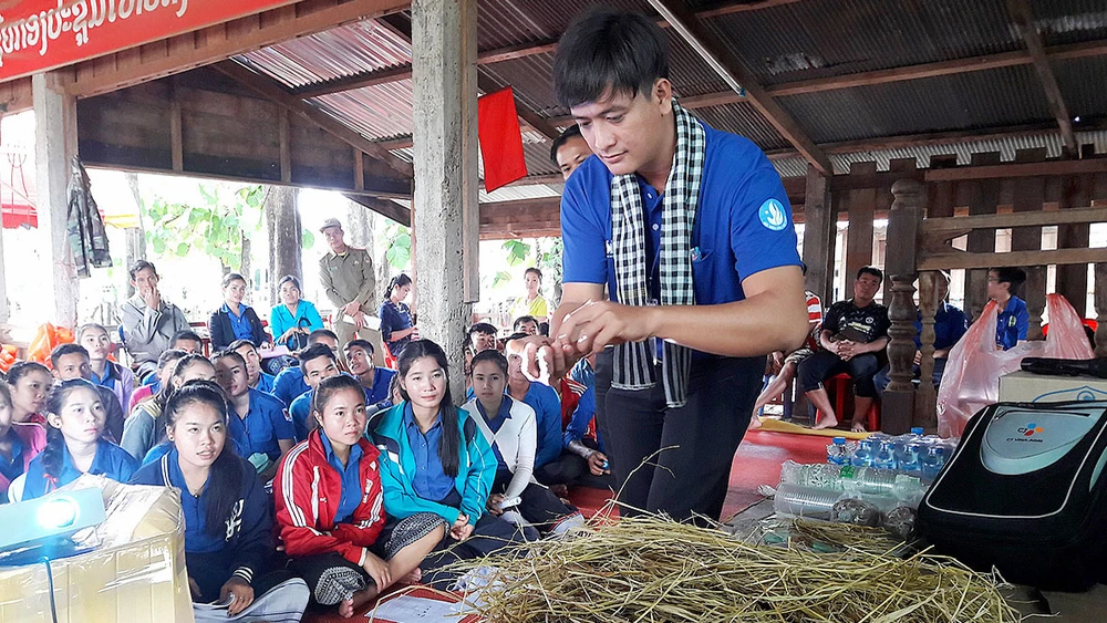 Chiến sĩ tình nguyện Mùa hè xanh tập huấn cách trồng nấm cho người dân, thanh niên nước bạn Lào. Ảnh: THU HƯỜNG