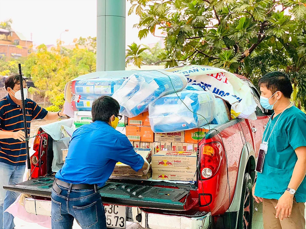 Thành viên Câu lạc bộ Xe bán tải Đà Nẵng đưa hàng hóa, nhu yếu phẩm, đồ bảo hộ chống dịch đến các khu cách ly. Ảnh: NGUYỄN CƯỜNG