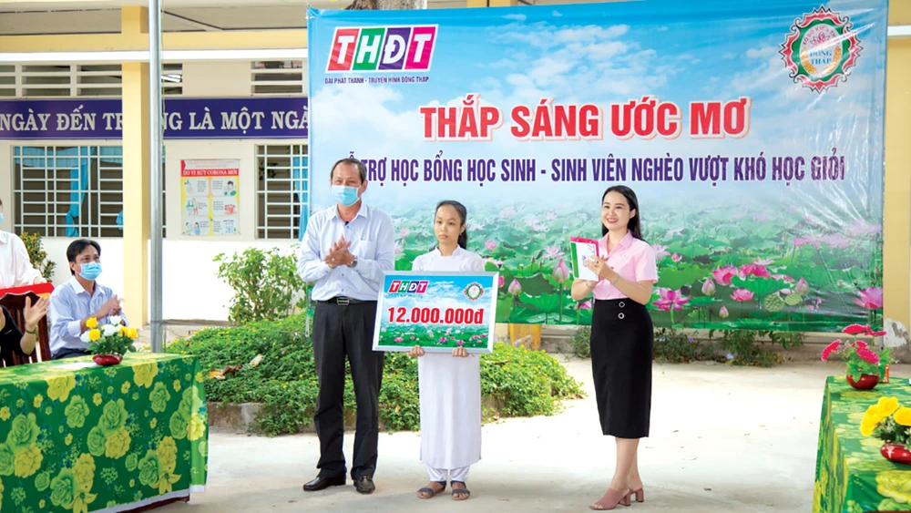 Ông Lưu Hoàng Tân - Chủ tịch, Giám đốc Công ty TNHH MTV XSKT Đồng Tháo trao học bổng cho em Đỗ Thị Kim Ngân