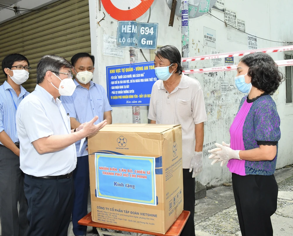 Chủ tịch UBND TPHCM Nguyễn Thành Phong trao quà hỗ trợ người dân ở "vùng xanh" tại quận Phú Nhuận. Ảnh: VIỆT DŨNG