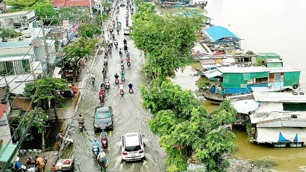 Triều cường gây ngập trên đường Trần Xuân Soạn, phường Tân Thuận Tây, quận 7. Ảnh: HOÀNG HÙNG