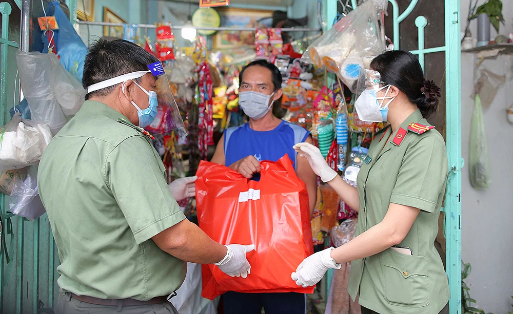 Công an quận 4, TPHCM tặng quà cho người nghèo bị ảnh hưởng bởi dịch Covid-19. Ảnh: DŨNG PHƯƠNG