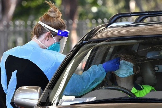 Nhân viên y tế lấy mẫu xét nghiệm Covid-19 cho người dân tại Sydney, Australia ngày 28-7-2021. Ảnh: AFP/TTXVN