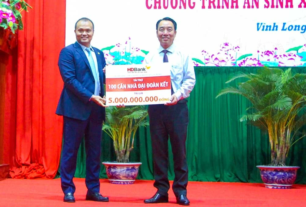 Ông Nguyễn Đăng Thanh – Phó Tổng Giám đốc HDBank (trái) trao tặng kinh phí xây dựng 100 căn nhà đại đoàn kết, ông Lữ Quang Ngời - Chủ tịch UBND tỉnh Vĩnh Long đại diện nhận