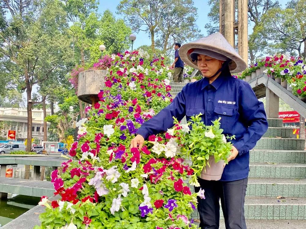 Chị Dung chăm sóc từng chậu hoa tại Hồ Con Rùa