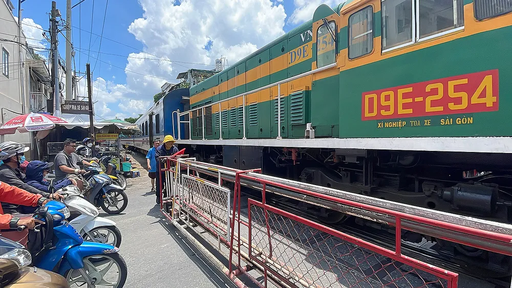 Đoàn tàu rời ga Sài Gòn di chuyển cắt ngang đường Đỗ Thị Lời, phường 11, quận 3. Ảnh: HOÀNG HÙNG