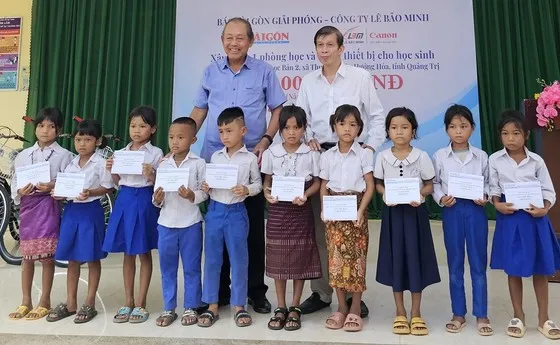 Nguyên Phó Thủ tướng Thường trực Chính phủ Trương Hòa Bình và Phó Tổng Biên tập Báo SGGP Nguyễn Khắc Văn trao tặng học bổng cho học sinh dân tộc thiểu số Vân Kiều, xã Thuận, huyện Hướng Hóa, tỉnh Quảng Trị