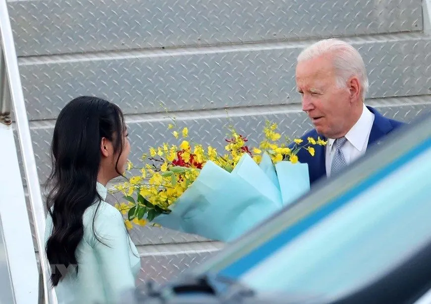 Thiếu nữ Thủ đô tặng hoa chào mừng Tổng thống Joe Biden đến Hà Nội. Ảnh: TTXVN