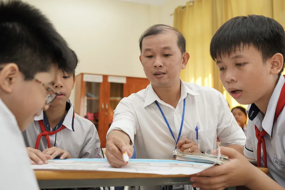Thầy Nguyễn Văn Hưng, giáo viên Trường THCS Nguyễn Trãi, quận Tân Phú, hướng dẫn học sinh cách trình bày và thiết kế sa hình. Ảnh: HOÀNG HÙNG