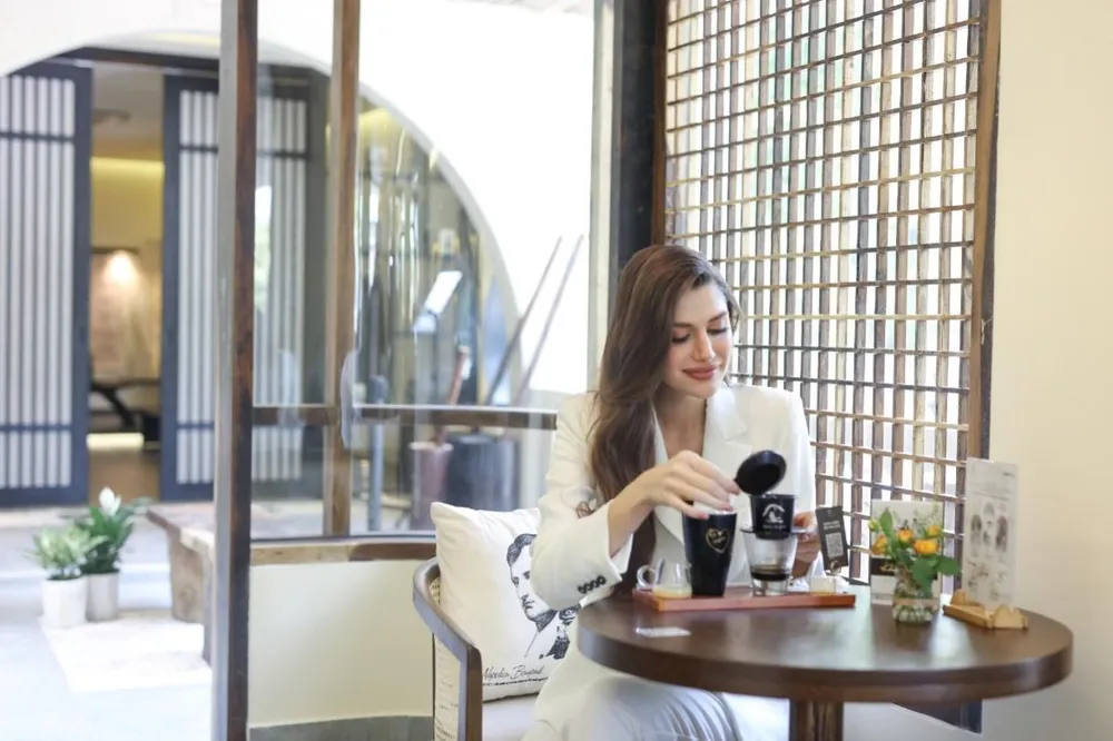 Hoa hậu Hòa bình Quốc tế Isabella Menin thưởng thức ly cà phê sữa đá - một trải nghiệm hấp dẫn về văn hóa cà phê Việt Nam. Ảnh: Discovery Hoa hậu Hòa bình Quốc tế Isabella Menin thưởng thức ly cà phê sữa đá - một trải nghiệm hấp dẫn về văn hóa cà phê Việt Nam. Ảnh: Discovery