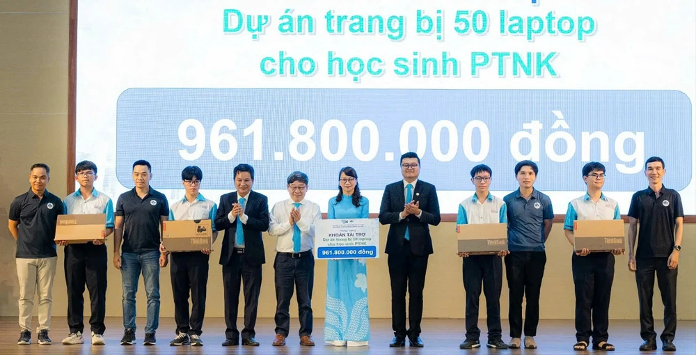 Thầy Nguyễn Thanh Hùng (áo sơ mi trắng) và một số cựu học sinh trao tặng laptop cho Trường Phổ thông Năng khiếu. Ảnh: V.H.