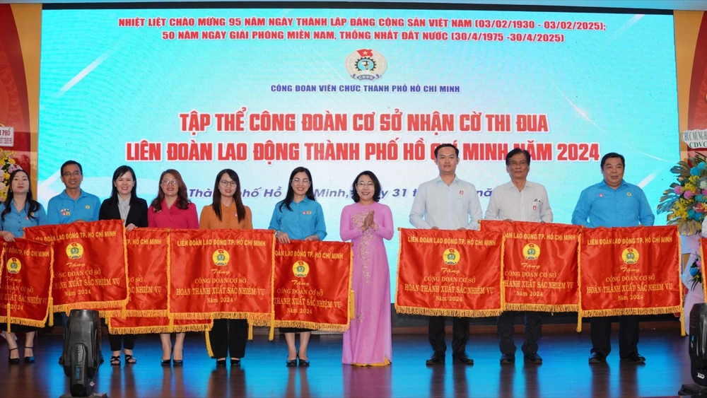 Phó Bí thư Đảng ủy Khối Dân – Chính – Đảng TPHCM Hàng Thị Thu Nga trao cờ thi đua của LĐLĐ TPHCM đến các tập thể