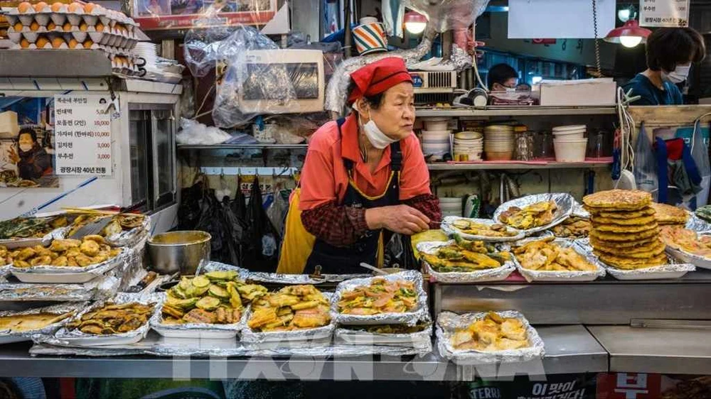 Người dân bán thực phẩm tại khu chợ Gwangjang ở Seoul, Hàn Quốc. Ảnh: AFP/TTXVN