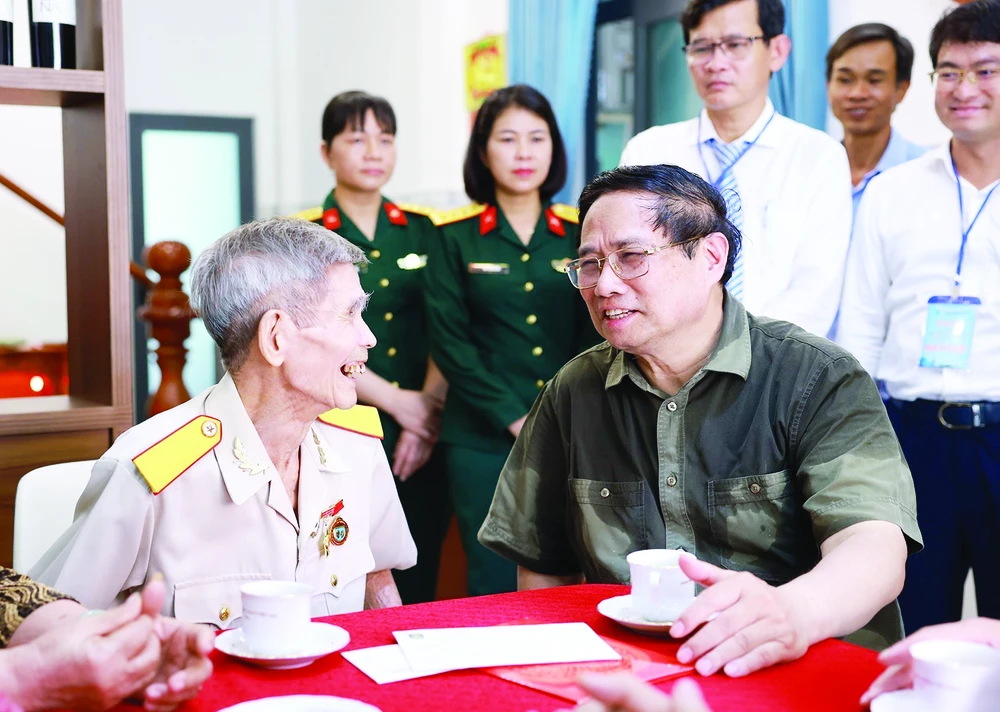 Thủ tướng Phạm Minh Chính thăm, tặng quà thương binh Nguyễn Xuân Viên, cựu tù Côn Đảo. Ảnh: TTXVN CN2b.jpg