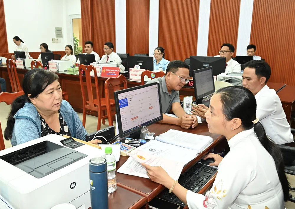 Hướng dẫn người dân làm thủ tục hành chính tại Trung tâm dịch vụ hành chính công phường Tam Bình, TPHCM. Ảnh: VIỆT DŨNG !3a.jpg
