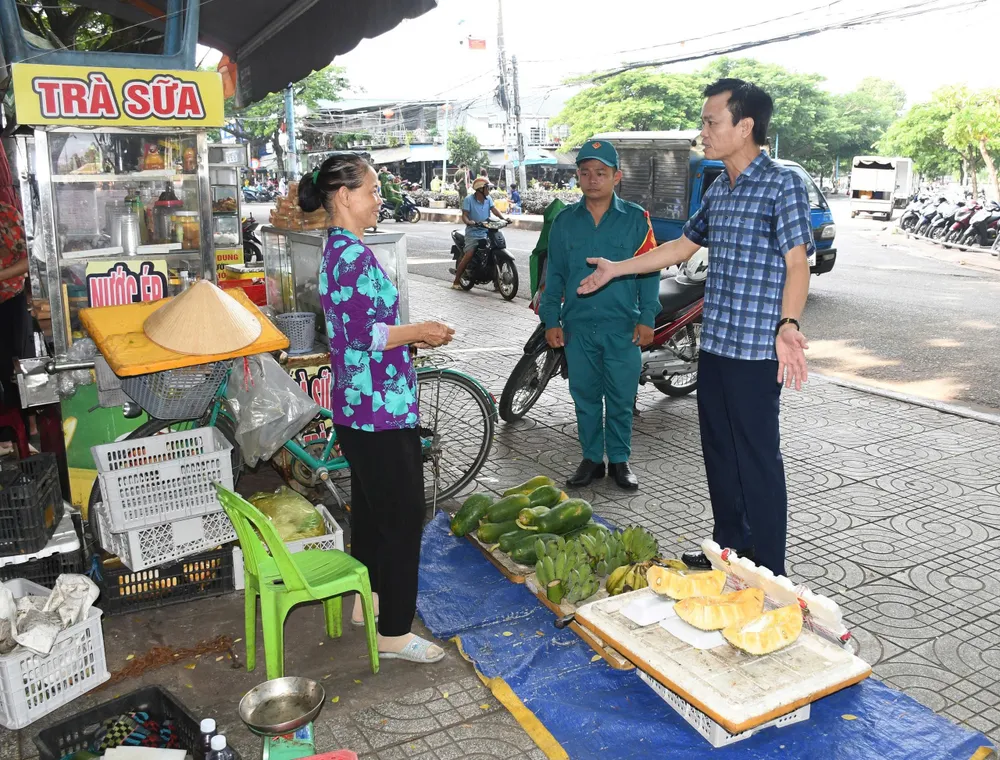Ông Nguyễn Việt Dũng, Chủ tịch UBND phường Phước Thắng vận động hộ kinh doanh không lấn chiếm vỉa hè buôn bán. Ảnh: HOÀNG HƯỜNG anh 1 trat tu do thi.jpg