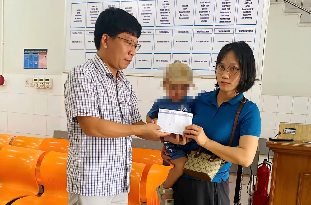 Trao tiền hỗ trợ cháu Lê Minh Hoàng chữa bệnh mo mat.jpg