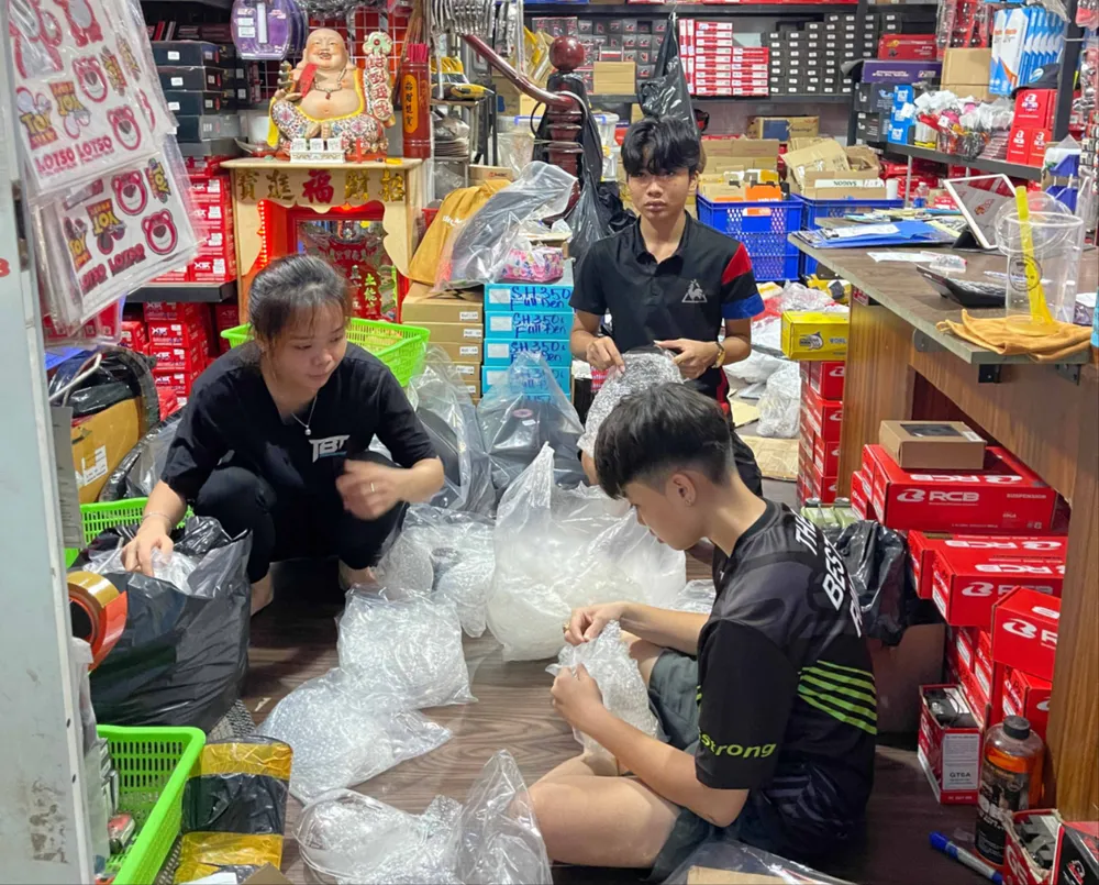 Cửa hàng phụ tùng xe gắn máy tại chợ Tân Thành (TPHCM) chuẩn bị giao hàng cho khách sau khi được rao bán trên mạng. Ảnh: HOÀNG HÙNG M5C.jpg