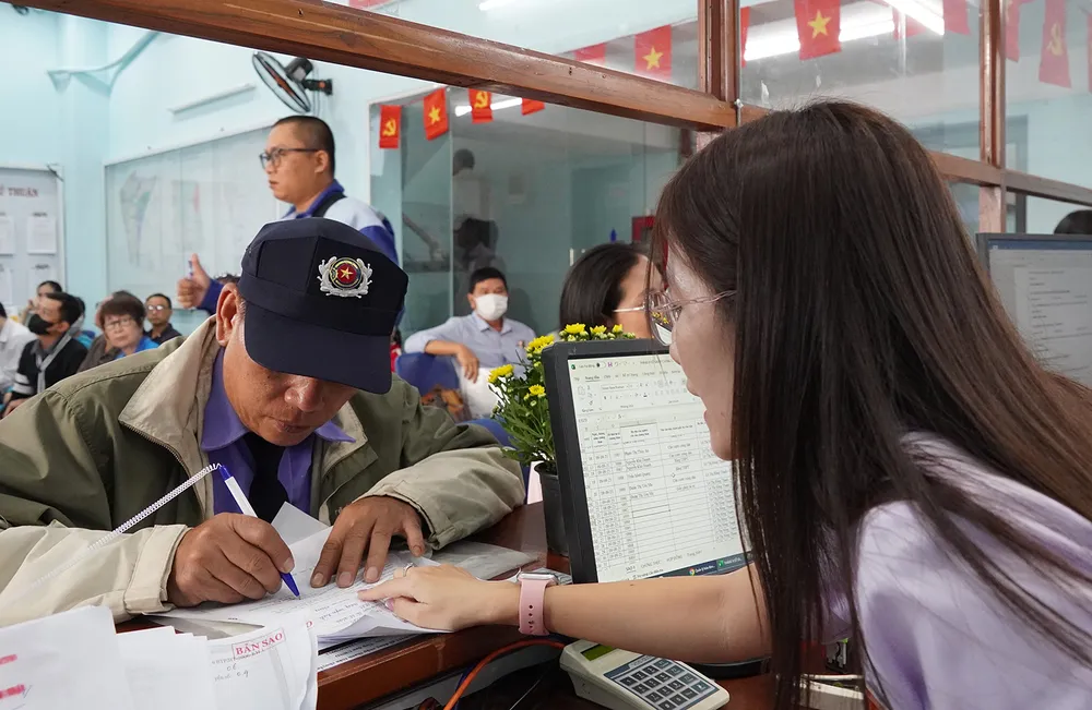 Công chức phường Phú Thuận (TPHCM) giải quyết thủ tục hành chính cho người dân. Ảnh: THU HƯỜNG I3a.jpg