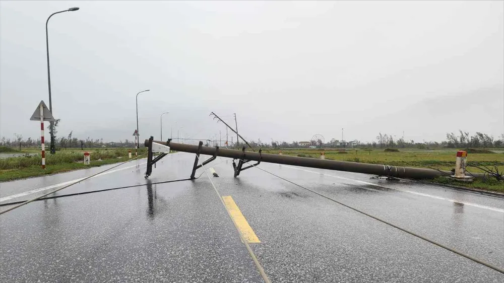 Trụ điện gãy, chắn ngang đường. Ảnh: DƯƠNG QUANG